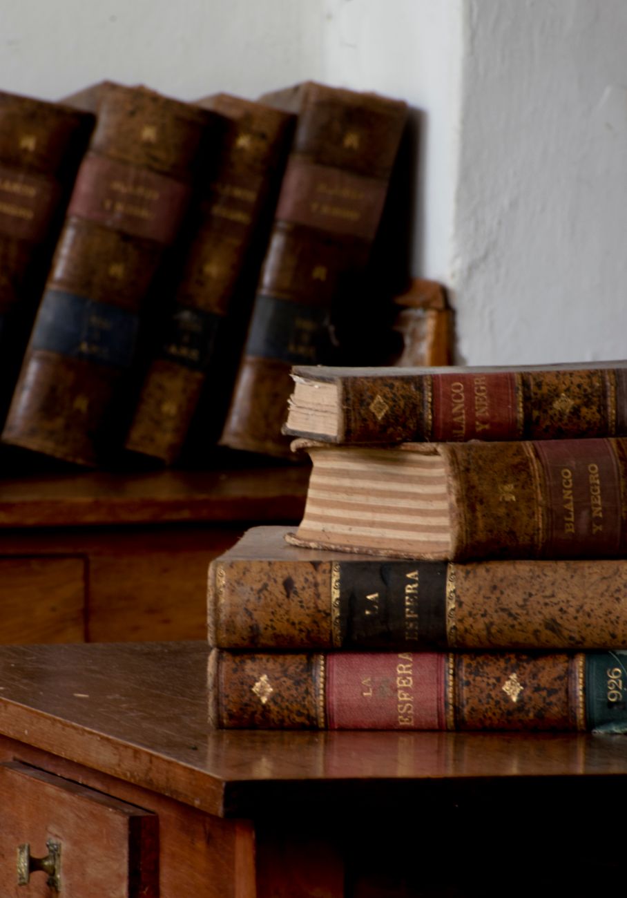 vintage leather bound books on wooden desk